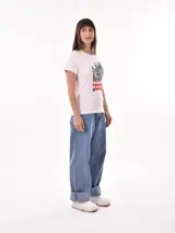 Remera negra de algodón con estampado frontal de la palabra "MERCI" en letras delineadas con colores del arcoíris.