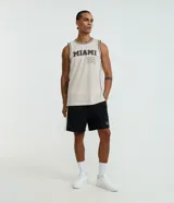 Bermuda deportiva para hombre, color negro, confeccionada en poliéster. Presenta un corte recto y holgado, con un panel lateral blanco que contrasta con el cuerpo principal. Tiene cintura elástica con cordón ajustable y un pequeño parche con logo en la pierna derecha.