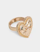 Anillo dorado con forma de corazón y moño.