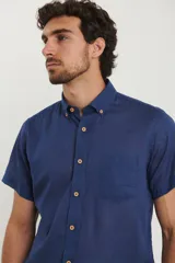 Camisa celeste de manga corta con cuello abotonado y bolsillo en el pecho.