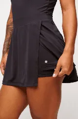 Vestido deportivo color verde con logo bordado en blanco en el pecho. Diseño sin mangas, con cuello mao y cierre parcial con botones. Falda con corte evasé y short interno.