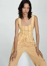 Pantalón color beige de tiro medio y corte ancho, con bolsillos laterales, bolsillos cargo y bolsillos de parche en la parte posterior.