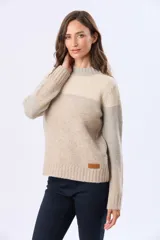 Buzo tejido con diseño de bloques de color en rosa, gris claro y beige. Posee un cuello alto y corte holgado.