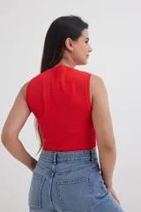 Top tejido fucsia con cuello redondo y sisas amplias.
