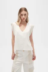 Blusa sin mangas de lino y viscosa, color blanco con laterales en beige, corte holgado y cuello en V.