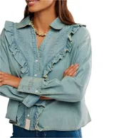 Camisa amplia de chambray celeste con botones al frente y detalles de volados. Tiene cuello clásico, pliegues y hombros caídos.