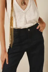 Jean de tiro medio, lavado azul oscuro, con calce ajustado hasta la rodilla y pierna acampanada estilo setentista.