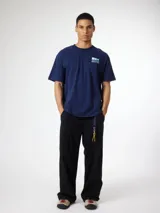 Camiseta gris de algodón con cuello redondo y manga corta. Estampado en la espalda con diseño geométrico de cuadrados en tonos verde y celeste.