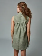 Vestido corto sin mangas, con cuello camisero y abotonadura frontal, confeccionado en lino a rayas color ladrillo.