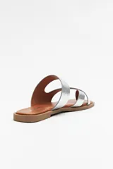 Sandalias bajas doradas con capellada de cuero sintético y agarre para el dedo gordo.