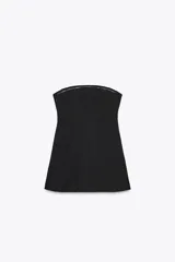 Vestido corto negro sin mangas, con escote palabra de honor y pespuntes marcados. Cierre trasero con cremallera oculta.