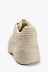 Zapatillas deportivas color beige con plataforma alta. Cierre con cordones.