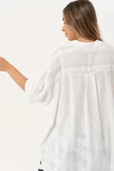 Camisa blanca con calados, escote en V, abotonada y manga 3/4.