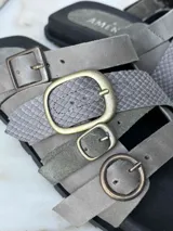 Sandalias de cuero marrón con tres tiras anchas y hebillas doradas.