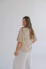 Blusa beige de mangas cortas con volados y escote en V.