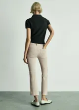 Pantalón de jean color beige, de corte flare y tiro alto.