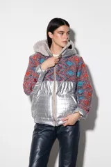 Campera con parte superior de paño de lana color crema y parte inferior impermeable plateada. Forrada con peluche y capucha desmontable.