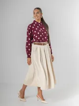 Falda midi de corderoy color beige claro, con pliegues verticales marcados y cintura elastizada. Incluye un cinturón desmontable de cuero marrón con hebilla dorada.