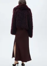 Falda maxi color crema de tejido satinado con goma elástica en la cintura y abertura lateral.