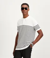 Polo de hombre con corte comfort, confeccionada en tejido de punto de algodón a rayas horizontales blancas y negras. Tiene cuello inglés con botones y mangas cortas.