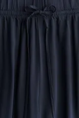 Pantalón azul marino de viscosa, tiro alto, corte holgado, piernas rectas y cintura elástica con cordón ajustable.