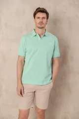 Chomba azul marino de piqué con cuello clásico, tapeta de dos botones y logo de pájaro bordado en color rosa en el pecho.