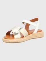 Sandalia con tiras cruzadas doradas con textura de piel de serpiente y ajuste con hebilla en el tobillo. Base tejida tipo esparto y plantilla acolchada.