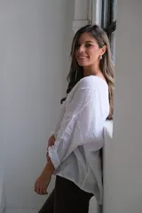Blusa blanca de lino con mangas 3/4 y diseño de paneles con costuras a la vista.