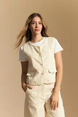 Chaleco negro de vestir con cuello solapa y cierre frontal de botones. Presenta costuras contrastantes blancas que definen el diseño y bolsillos delanteros. Se combina con una camisa blanca de manga larga.