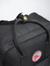 Mochila negra de poliéster con revestimiento de PU, con dos asas de mano y correas ajustables para los hombros. Tiene un compartimento principal con cierre, un bolsillo frontal con cierre y dos bolsillos laterales abiertos.