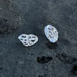 Par de aros colgantes de bronce y alpaca con diseño abstracto calado.