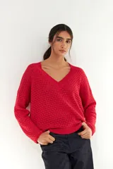 Sweater rojo de tejido de punto calado con escote en V y mangas largas.
