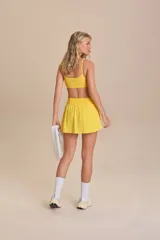 Pollera deportiva color verde lima, con short interno y bolsillo en la cintura.