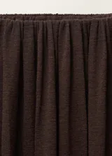 Falda larga marrón con cintura elástica, bajo abullonado y detalle fruncido en la cintura. Confeccionada en tejido mezcla de viscosa y lana.