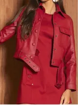 Chaqueta corta color bordó de cuero sintético, con cuello clásico, cierre frontal con botones a presión, bolsillos con solapa en el pecho y mangas largas con puños abotonados.
