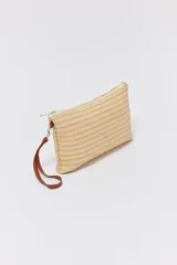 Sobre necessaire de paja color beige con cierre superior y correa de mano marrón.
