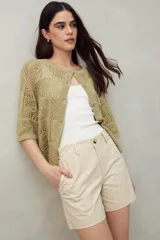 Short color beige de tiro medio, con bolsillos delanteros y traseros.
