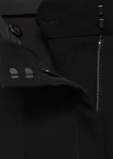 Pantalón de mujer negro, de corte acampanado y tiro alto, con bolsillos laterales y traseros.