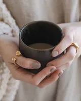 Anillo dorado con diseño de tres bandas entrelazadas.