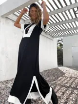 Vestido largo negro con paneles blancos en escote, mangas y ruedo.