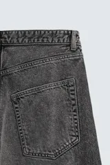 Pantalón de jeans de algodón, corte baggy fit, tiro medio, con efecto lavado en tonos grises y verdes. Presenta cinco bolsillos y cierre frontal con cremallera y botón.