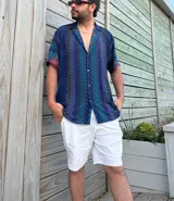 Camisa de manga corta con estampado abstracto en tonos azules, verdes y rojos.