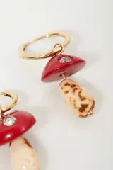 Aros de argolla dorada con dije colgante en forma de hongo de resina roja y blanca con incrustaciones de strass.