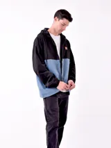 Campera con capucha azul marino y beige con cierre frontal y logo en el pecho.