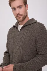Sweater de punto trenzado color marrón con cuello alto y cierre de cremallera.