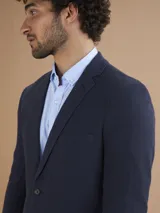 Blazer azul marino de corte clásico con solapa de muesca, cierre de dos botones y bolsillos laterales con solapa.