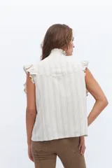 Chaleco celeste de lino con cuello mao, cierre frontal con botones y volados en hombros y bolsillos.