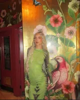 Vestido midi ajustado de microtul verde con estampado abstracto en tonos oscuros. De mangas largas y cuello redondo, es una prenda transparente y elástica.