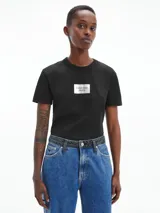 Remera negra de corte slim fit, cuello redondo y manga corta. Presenta un logo rectangular de Calvin Klein Jeans en el pecho.