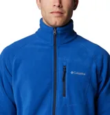 Chaqueta de forro polar color azul con cierre frontal completo y cuello alto. Presenta un bolsillo vertical con cremallera en el pecho con el logo de Columbia y bolsillos laterales con cremallera. Confeccionada en microfibra de poliéster ligera para mayor comodidad en actividades al aire libre.